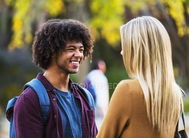 Boyfriend and girlfriend having a conversation and smiling to each other — Stock Photo