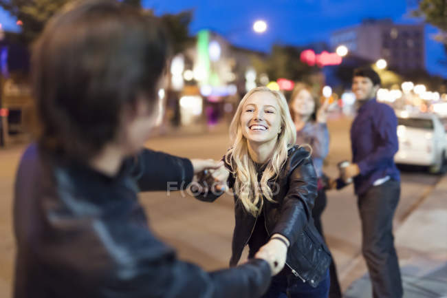 Пара игривая на тротуаре города в ночное время — стоковое фото