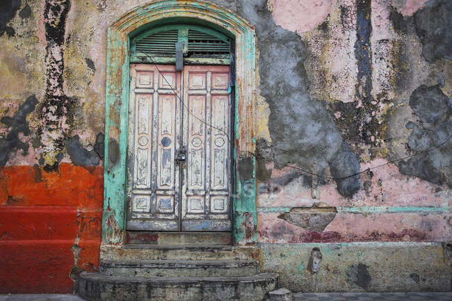 Facciata indossata e intemperie di un edificio con vernice peeling e doppie porte; Nicaragua — Foto stock