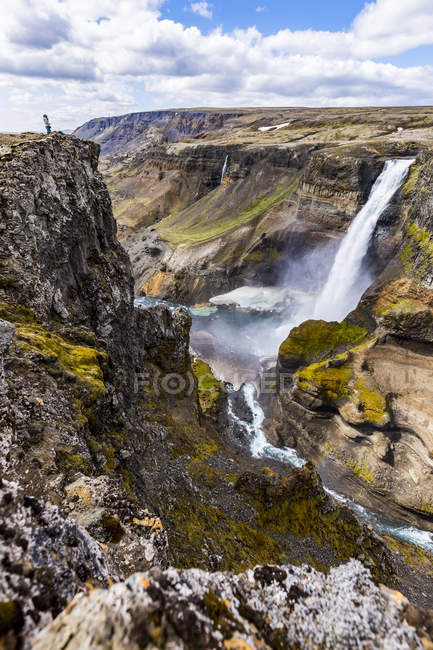 Жіночий мандрівного на краю високій скелі над долиною водоспад Haifoss, Ісландія — стокове фото