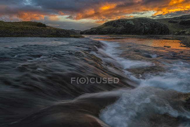 Belo pôr do sol sobre um riacho na Islândia rural; Islândia — Fotografia de Stock