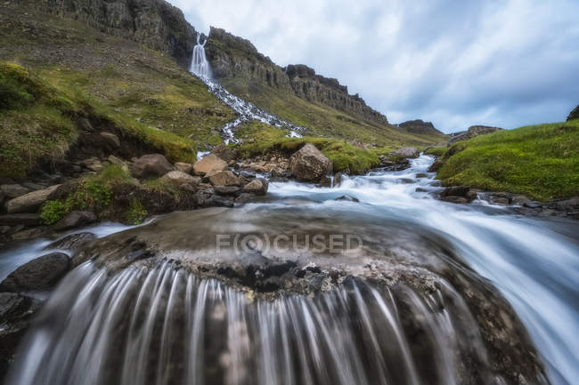 Desfoque de movimento de água corrente em uma cachoeira perto de Djupavik; Fiordes Ocidentais, Islândia — Fotografia de Stock