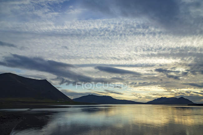 Coucher de soleil et ciel nuageux au-dessus d'un bras de mer reculé dans l'ouest de l'Islande sur la péninsule Snaefellsnes, Islande — Photo de stock