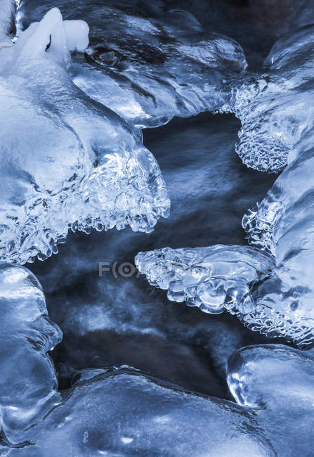 Se forman hermosos patrones de hielo cuando el agua continúa corriendo mientras un arroyo se congela; Djupavik, West Fjords, Islandia - foto de stock
