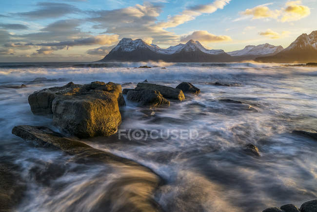 Pôr do sol sobre as montanhas da costa de Strandir, Islândia como o surf libras a costa; Fiordes ocidentais, Islândia — Fotografia de Stock