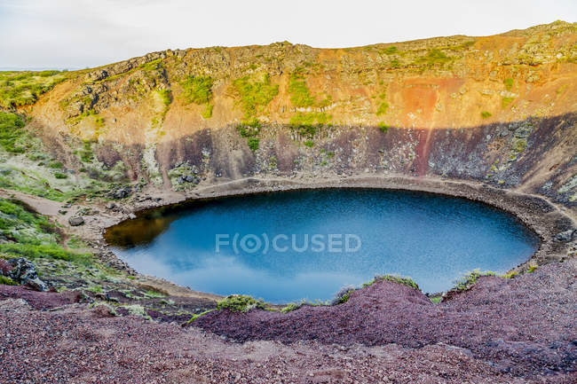Кратера вулкана Kerid є популярною туристичною визначною пам'яткою на маршруті Золоте коло у західній Ісландії і Ісландська — стокове фото