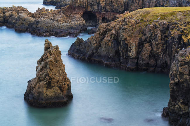 Amazing scenery along a remote section of the West Fjords with great autumn colours and a sea stack in the ocean; West Fjords, Iceland — Stock Photo