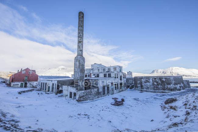 Живописный вид заброшенного завода сельди в снегу, Джупавик, Западные Фьорды, Исландия — стоковое фото