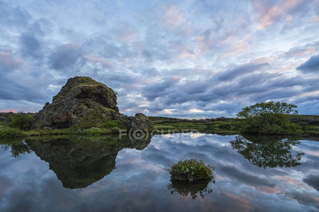 Sunset over the old lava and small pond near Lake Myvatn, North Iceland; Iceland — Stock Photo