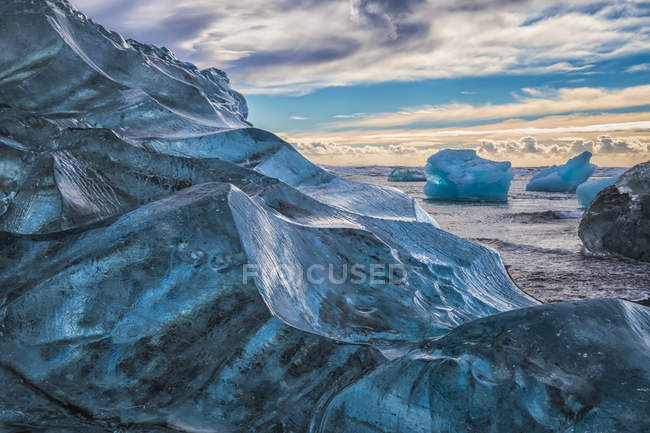 Jokulsarlon ou Diamond Beach, avec de grands morceaux de glace jonchant la plage entre chaque marée haute ; Islande — Photo de stock
