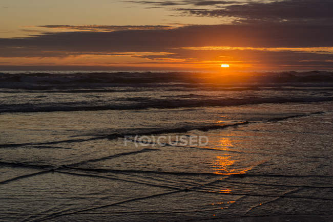 Il sole tramonta sulla spiaggia e riflette sull'acqua con vista sull'orizzonte, Tolovana Park, Oregon, USA — Foto stock