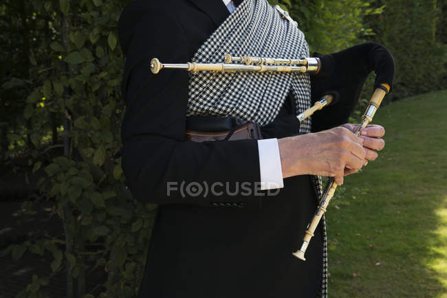 Immagine ritagliata di musicista con piccoli tubi northumbriani — Foto stock