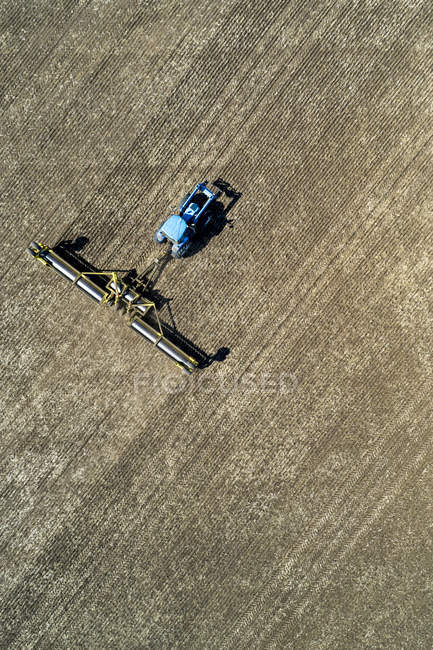 Luftaufnahme eines Traktors, der Rollen zieht, um ein Feld zu glätten — Stockfoto