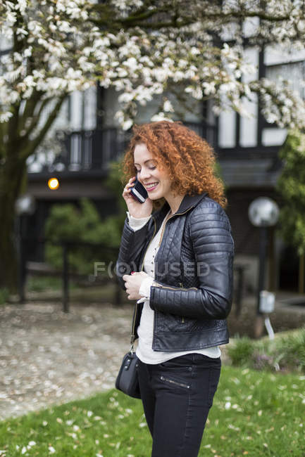 Mulher falando em um telefone celular enquanto estava do lado de fora — Fotografia de Stock