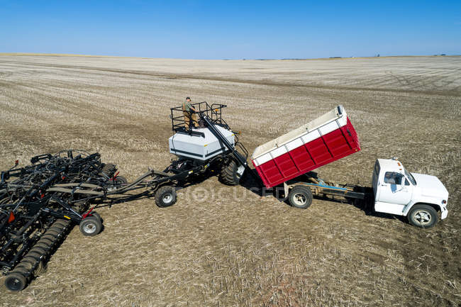 Agriculteur masculin travaillant avec des machines lourdes sur le terrain — Photo de stock