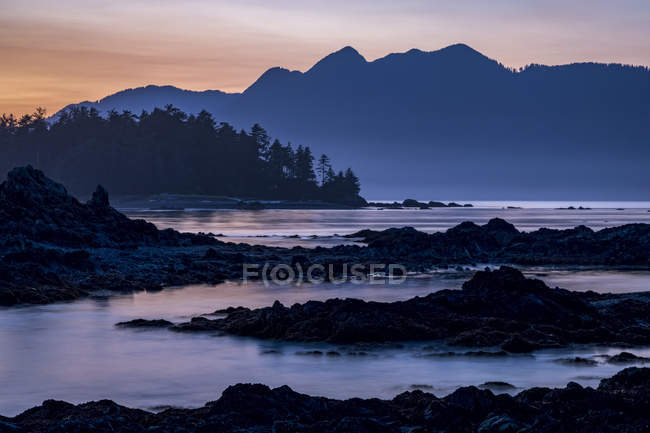 Chutes du crépuscule sur l'île de Vancouver vues depuis un îlot du parc provincial Nuchatlitz, Colombie-Britannique, Canada — Photo de stock