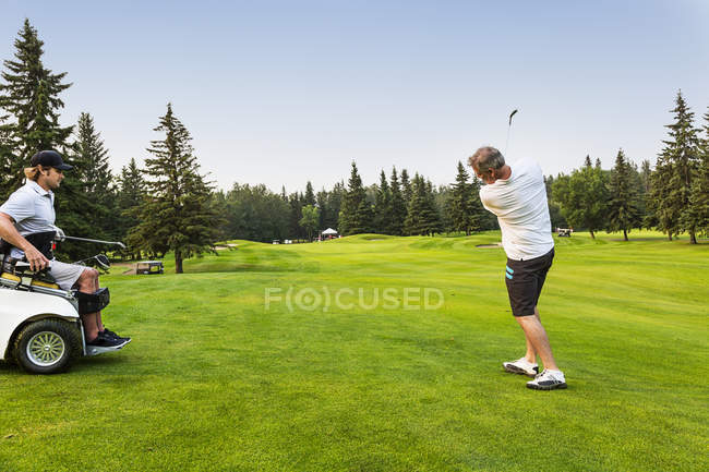 Гольфист, бьющий мячом по фарватеру поля для гольфа, Эдмонтон, Альберта, Канада — стоковое фото