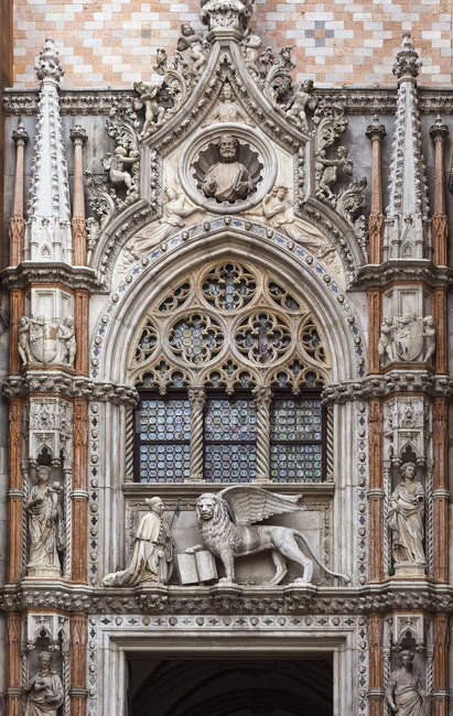 Estatua de Doge y león alado, símbolo de San Marcos, por encima de la puerta de entrada al Palacio Ducal, Plaza de San Marcos, Venecia, Italia - foto de stock