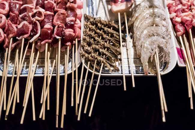 Street vendor with skeewers ready to be cooked; Beijing, China — Stock Photo