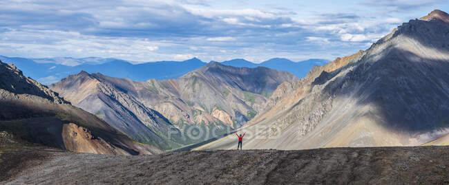 Donna in piedi con le braccia alzate mentre si trova su una linea di cresta nel Kluane National Park and Reserve; Haines Junction, Yukon, Canada — Foto stock