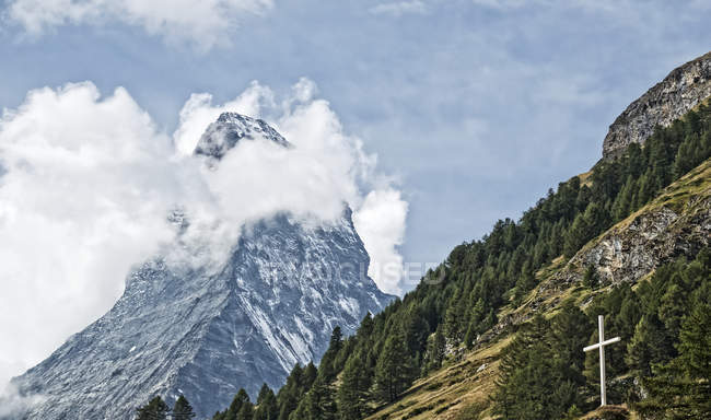 Cervino con croce bianca sul fianco della montagna in primo piano; Zermatt, Svizzera — Foto stock