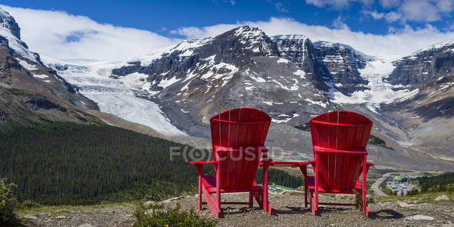 Deux chaises rouges debout sur un rocher contre un paysage montagneux, parc national Jasper ; Alberta, Canada — Photo de stock