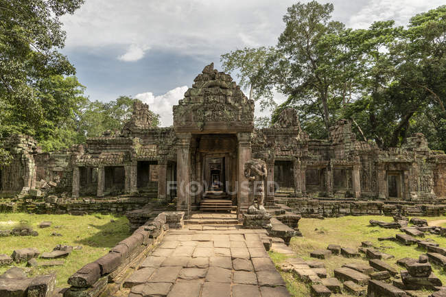 Fachada de templo de pedra guardada por estátua sem cabeça, Preah Khan, Angkor Wat, Siem Reap, província de Siem Reap, Camboja — Fotografia de Stock