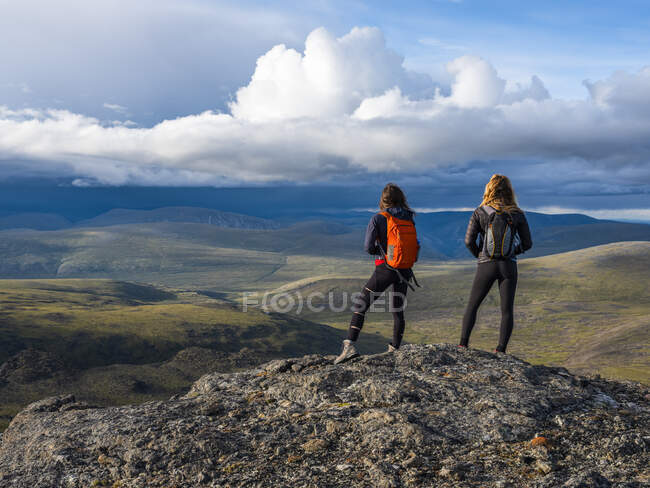 Dos mujeres explorando las montañas y el desierto del Yukón. Sentirse vivo y vibrante en el hermoso paisaje alrededor de Haines Junction; Yukón, Canadá - foto de stock