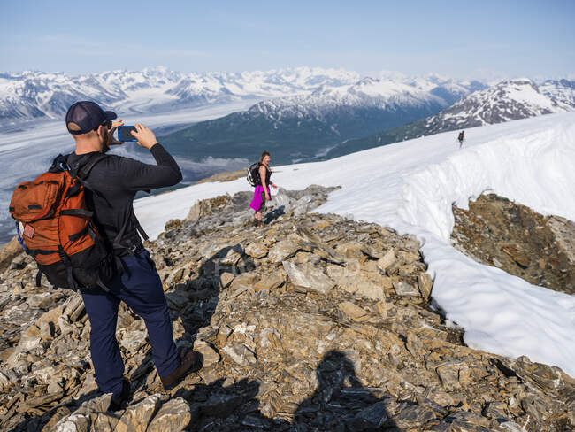 Taking photos with a cell phone on a mountaintop in Kluane National Park and Reserve; Haines Junction, Yukon, Canada — Stock Photo
