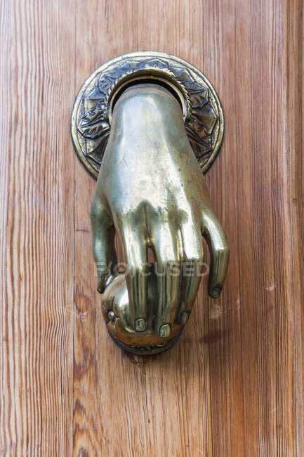 Door knocker in the form of a brass hand; Pisa, Italy — Stock Photo
