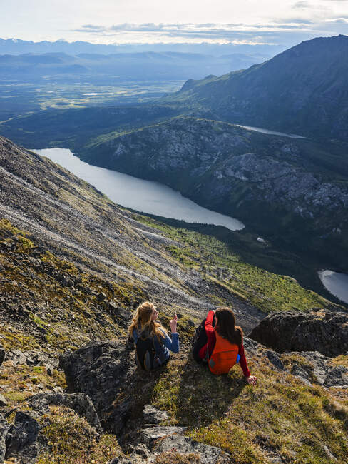 Two women exploring the mountains and wilderness of the Yukon. Feeling alive and vibrant in the beautiful scenery around Haines Junction; Yukon, Canada — Stock Photo