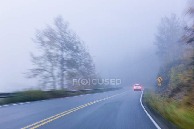 Langsame Belichtungszeit eines Autos, das auf einer nebligen Straße fährt, Süd-Zentralalaska, Palmer, Alaschka, Vereinigte Staaten von Amerika — Stockfoto