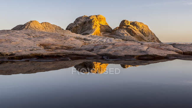 Tasca bianca con luce solare dorata sulle formazioni rocciose al tramonto, Vermilion Cliffs National Monument; Arizona, Stati Uniti d'America — Foto stock
