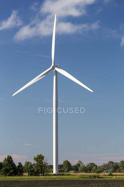 Molino de viento de metal grande en un campo agrícola con cielo azul y nubes, al oeste de Port Colborne, Ontario, Canadá - foto de stock