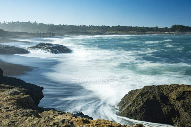 Waves softened by a long exposure surge onto the beach at MacKerricher State Park and Marine Conservation Area near Cleone in Northern California, Cleone, California, United States of America — Stock Photo