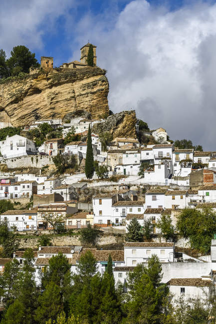 Руины мавританского замка на вершине холма с домами, заполняющими склон холма, Монтефрио, провинция Гранада, Испания — стоковое фото