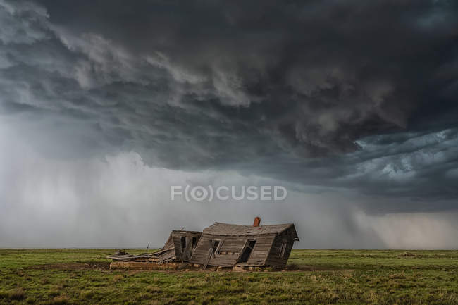 Драматическое небо над ландшафтом видно с разрушенным зданием во время турне в погоне за бурей на среднем западе Соединенных Штатов; Канзас, Соединенные Штаты Америки — стоковое фото