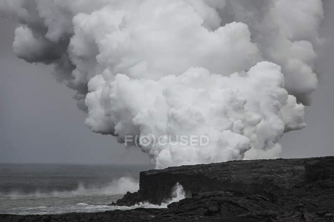 Humo de un flujo de lava procedente de Kilauea, un volcán escudo activo; Isla de Hawai, Hawái, Estados Unidos de América - foto de stock