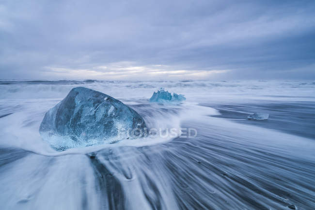 Великі льодові блоки, що покламають на берег Південного Ісландії, при аварії хвиль на березі; Ісландія — стокове фото