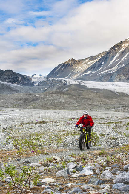 Uomo in sella alla sua fatbike nella Gulkana Glacier Valley, Alaska, Stati Uniti d'America — Foto stock