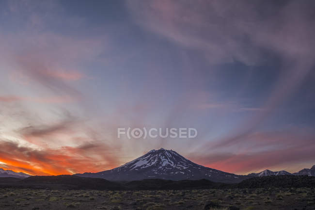 Заснеженные склоны вулкана на фоне красного закатного неба. Мендоса, Аргентина — стоковое фото