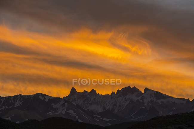 Pôr-do-sol vermelho intenso sobre uma gama distante de picos de montanhas nevadas afiadas, Mendoza, Argentina — Fotografia de Stock