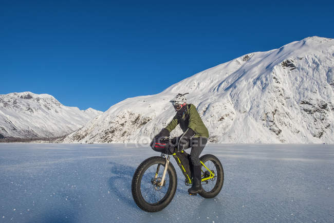 Mann fährt Fatbike über zugefrorenen Portage-See mitten im Winter in Süd-Zentralalaska, Vereinigte Staaten von Amerika — Stockfoto