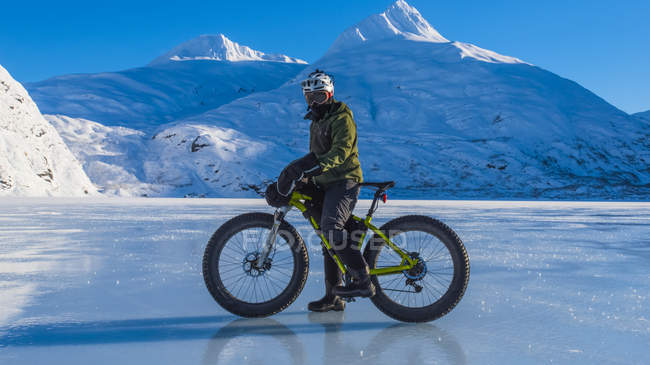 Людина їде на мотоциклі через замерзле озеро Портаж в середині зими в південно-центральній частині Аляски, Сполучені Штати Америки — стокове фото
