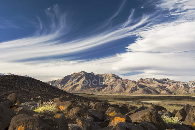 Vale de alta altitude e montanhas ao pôr do sol, com nuvens cirro pitorescas no céu azul, Mendoza, Argentina — Fotografia de Stock