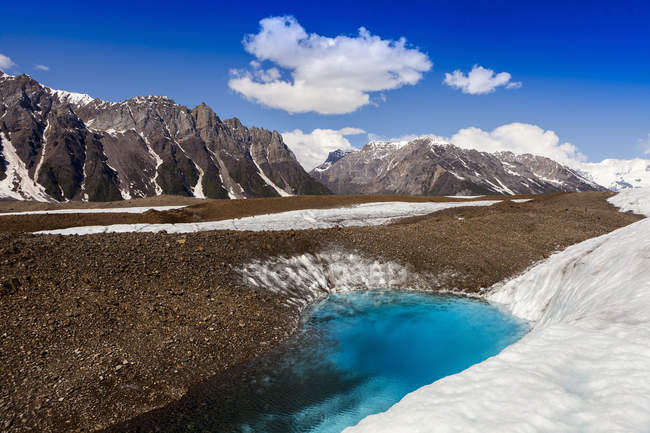 Glacial lake on Kennicott Glacier, with Wrangell Mountains in background, Wrangell, St. Elias National Park and Preserve; Alaska, United States of America — Stock Photo