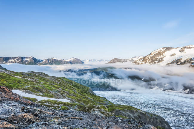 Тропа Ред-Рок в Восточном Аляскинском хребте в теплый солнечный летний день, на заднем плане ледник Кэнуэлл; Аляска, Соединенные Штаты Америки — стоковое фото