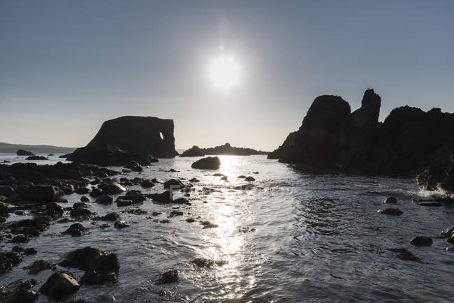 Silhouetted rock formations along the coast, Ireland — Stock Photo