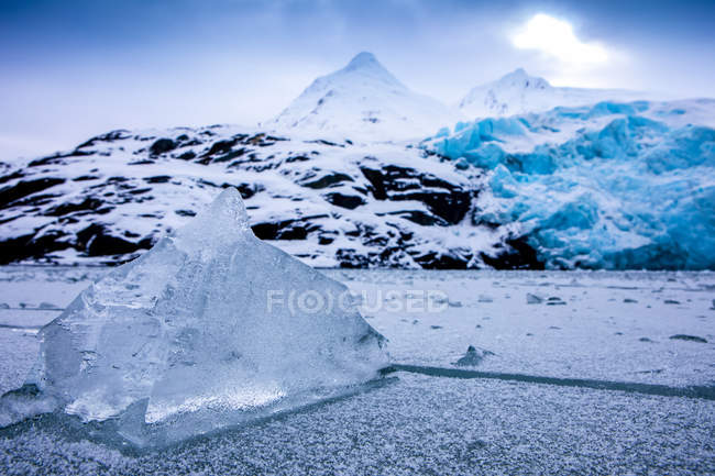 Lago Portage congelado en invierno con glaciar Portage en el fondo, hielo congelado en primer plano; Alaska, Estados Unidos de América - foto de stock