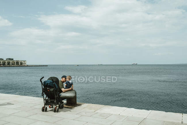 Père et bébé garçon sur une promenade au bord de l'eau sur la mer Adriatique ; Italie — Photo de stock